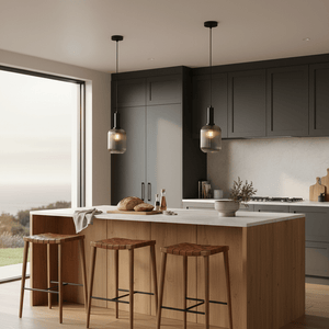 Two Athina Smoke Cut Glass Pendants hang over a modern kitchen island with wooden stools and a scenic view.