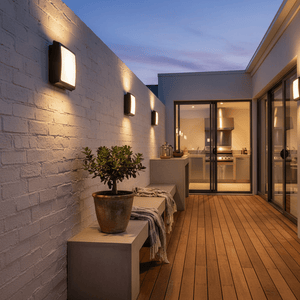 Outdoor setting featuring the Black Square ABS Bulkhead lights mounted on a white wall, illuminating a wooden deck.