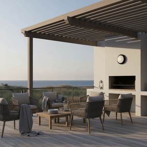 Outdoor patio scene featuring the Berta Bulkhead light mounted on a wall, with seating and ocean view.