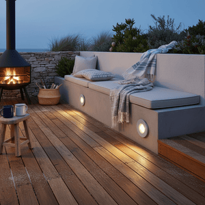 Outdoor seating area with a fire pit on a wooden deck at night.
