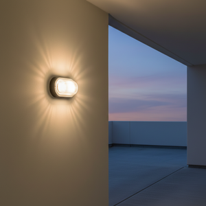 Outdoor wall light mounted on a smooth wall, casting warm light with a clear glass cover against a twilight sky.
