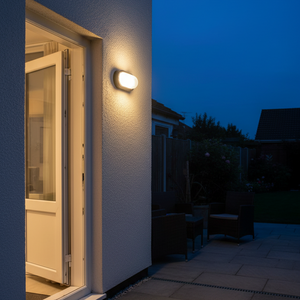 Outdoor wall light mounted beside a door, illuminating the entrance area at dusk.