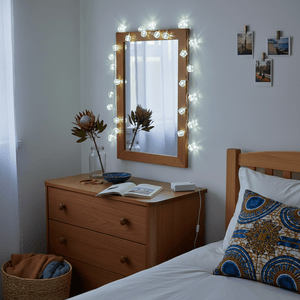 LED fairy lights with crystal caps draped around a mirror in a cozy bedroom setting.