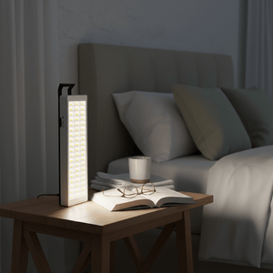 LED rechargeable emergency lantern on a bedside table, illuminating a book and glasses in a cozy bedroom setting.