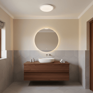 Stylish bathroom featuring a round mirror and wooden vanity, illuminated by a ceiling light.