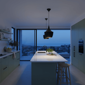 Stylish black metal pendant light hanging over a modern kitchen island with a scenic view.