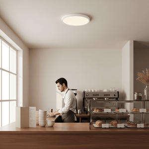 A modern café scene featuring an 18W LED ceiling light illuminating a barista at work.