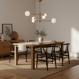 Stylish dining room featuring a gold pendant light above a wooden table set with plates and glasses.