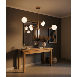 Gold pendant light with six globes above a wooden console table, featuring a mirror and decorative plants.