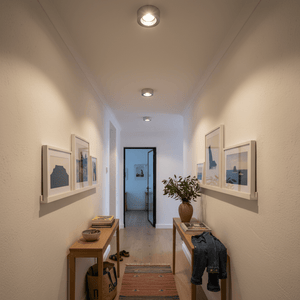 Hallway with framed pictures on the walls and a small table with decor items.