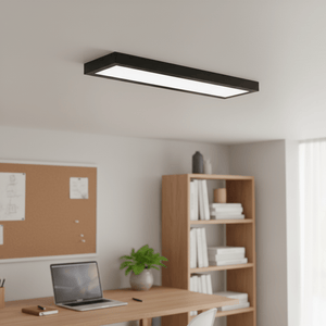 Sleek black linear LED panel light mounted on a ceiling above a modern office desk.
