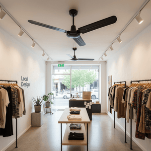 Black industrial ceiling fan with three blades installed in a modern retail space, surrounded by clothing displays.