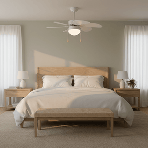 Modern white ceiling fan with six blades above a cozy bed in a softly lit bedroom.