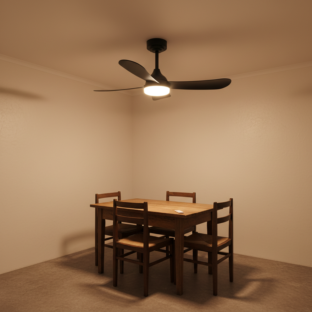 Black ceiling fan with integrated LED light above a wooden dining table and chairs in a simple room.