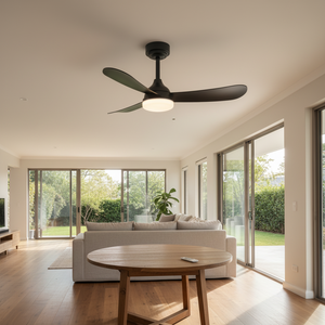 Black ceiling fan with integrated LED light in a modern living room setting, featuring a cozy sofa and large windows.
