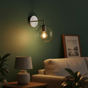 Satin silver wall light with glass globe illuminating a cozy living space, featuring a sofa and side table.