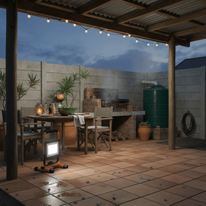 Portable LED floodlight illuminating an outdoor dining area with a rustic table and grill.