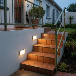 LED footlights illuminating outdoor stairs, providing gentle guidance with warm white glow.