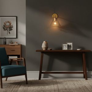 A gold wall light casts a warm glow above a wooden console table with decorative items.