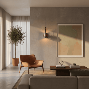 Modern wall-mounted LED sconce with metal and tinted glass, casting warm light beside a framed artwork.