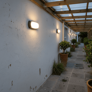 Outdoor wall with multiple Fumagalli Francy Bulkhead Lights illuminating a covered walkway.