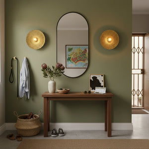 Entryway with a wooden console table, mirror, and wall lights on a green wall.