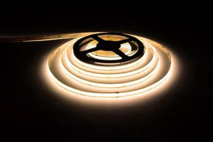 24V 8W COB CRI90 LED strip light emitting Warm White (3000K) light, shown as a flexible strip roll.