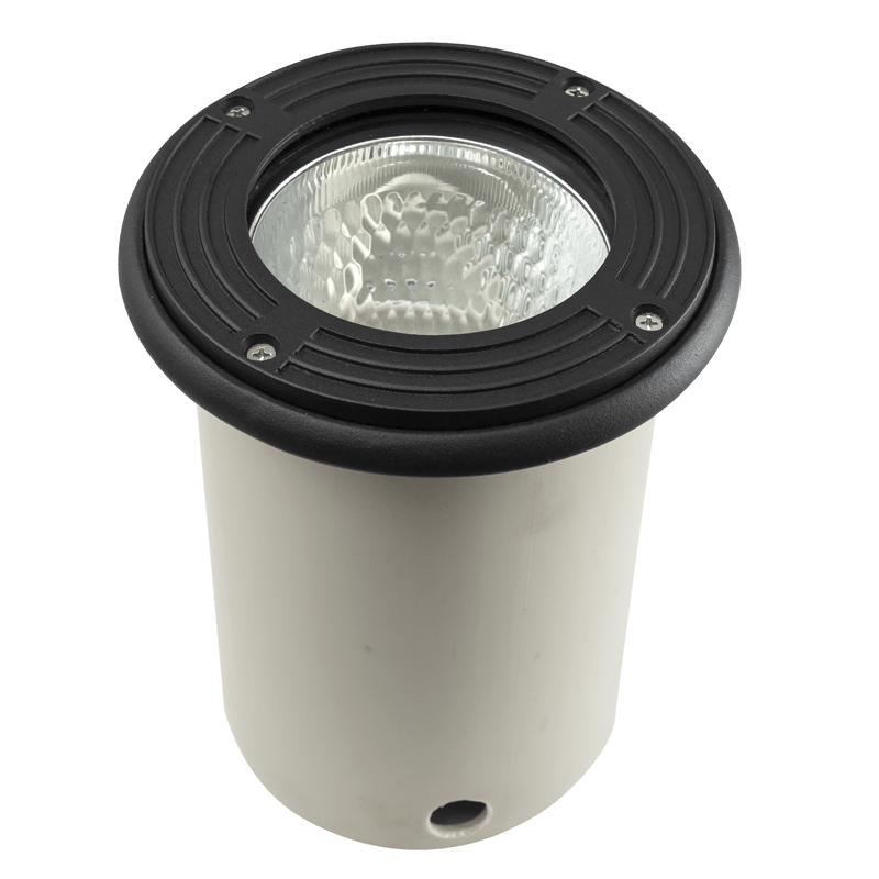 Black‑topped recessed ground light with clear textured lens and white cylindrical base, shown against a solid green