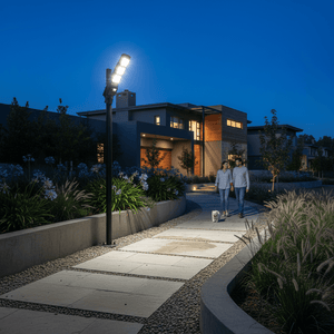 Couple walking a dog along a lit pathway with a solar street light illuminating the scene at dusk.