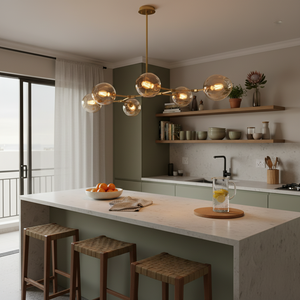 Satin gold pendant light with amber glass shades hanging over a modern kitchen island.