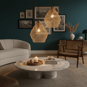 Two gold wire-mesh pendant lights hang above a marble coffee table in a stylish living room.