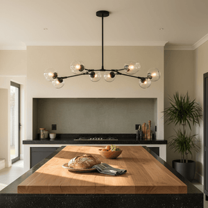 Elegant black 8-light pendant above a wooden kitchen island with bread and fruit.