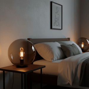A stylish bedroom scene featuring the Global Table Lamp on a bedside table, casting a warm glow.