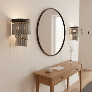 Elegant black crystal wall light mounted beside a round mirror in a stylish indoor setting.
