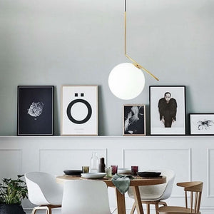 Stylish dining setup featuring the Humpty Large Pendant Light above a wooden table with decorative plates and art on the