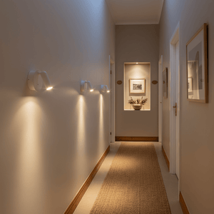 A hallway featuring multiple white rechargeable LED wall lights, illuminating the space with warm light.