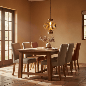 Golden Aura Steel Pendant Light hanging above a wooden dining table with upholstered chairs and a vase.