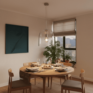 Clear glass dome pendant light hanging above a wooden dining table set with plates and glasses.
