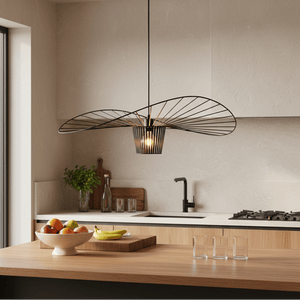 Stylish black pendant light hanging over a wooden kitchen island with fruit and glassware.