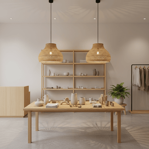 Two cone-shaped rattan bamboo pendant lights hanging above a wooden table with decorative items.