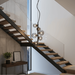 Modern black pendant light with glass bubbles hanging above a stylish staircase.