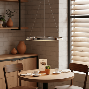 Chrome Hoop LED Pendant light hanging above a round wooden table with coffee cups and a small plant.