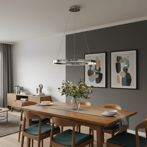 Chrome Hoop LED Pendant light hanging over a wooden dining table with a vase of greenery and decorative plates.