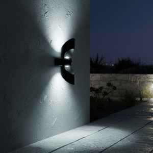 Uniq Up & Down LED Wall Light mounted on a textured wall, casting light upwards and downwards in a nighttime setting.