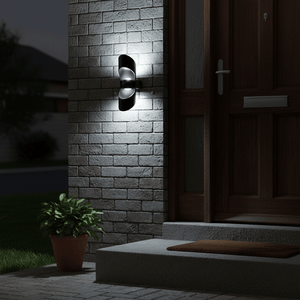 Uniq Up & Down LED Wall Light illuminating a brick wall beside a wooden door, with a potted plant nearby.