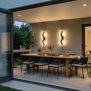 Bali Wave Outdoor Linear Wall Light illuminating a modern patio dining area with a wooden table and black chairs.