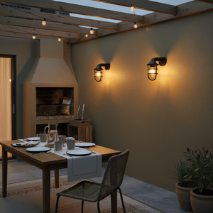Outdoor patio with two black LED wall lights illuminating a dining area with a table and chairs.