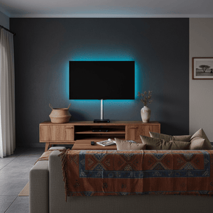 Modern living room with a television mounted on a dark wall, wooden cabinet, and patterned throw blanket.