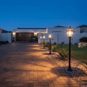 Coastal bollard lights illuminating a driveway with modern landscaping at dusk.