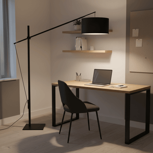 Stylish black floor lamp illuminating a modern desk setup with a laptop and chair.